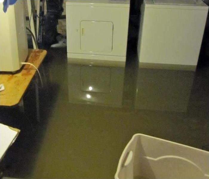 A flooded basement with washer and dryer
